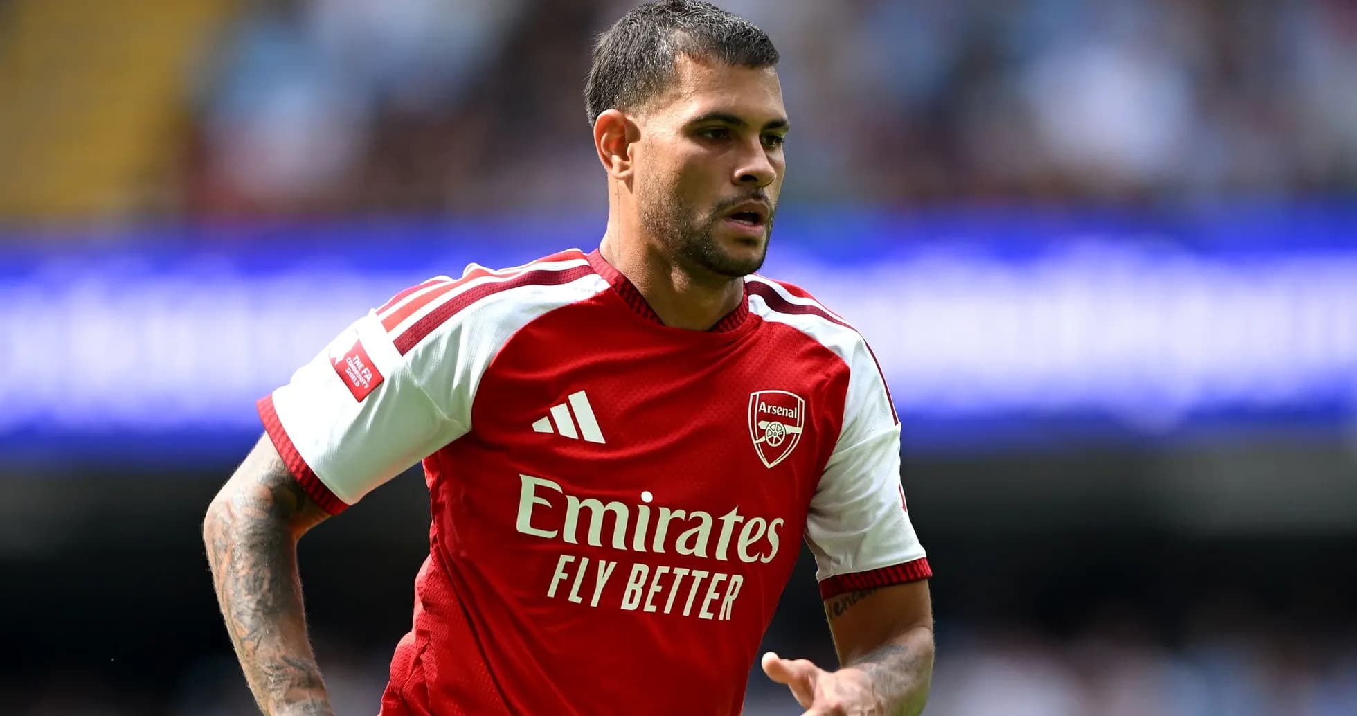 Player in Arsenal kit running on the field
