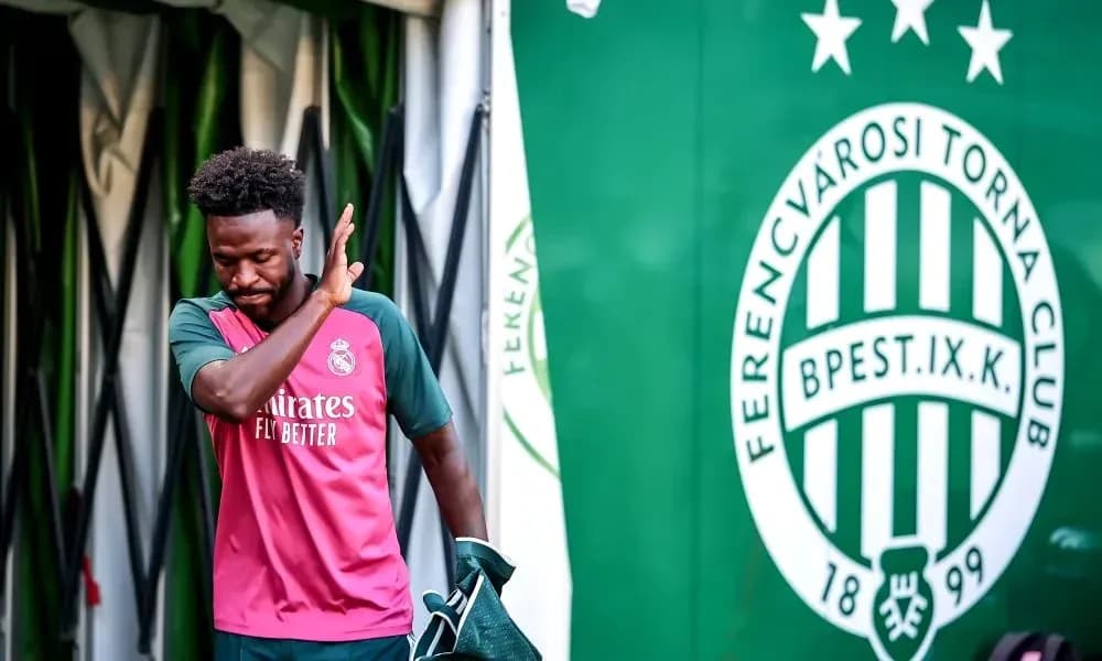 Player in Real Madrid kit walking past club logo