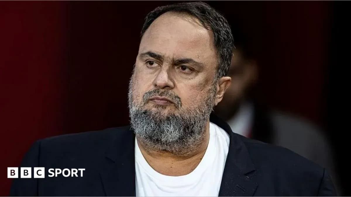 Man with beard in black suit looking serious