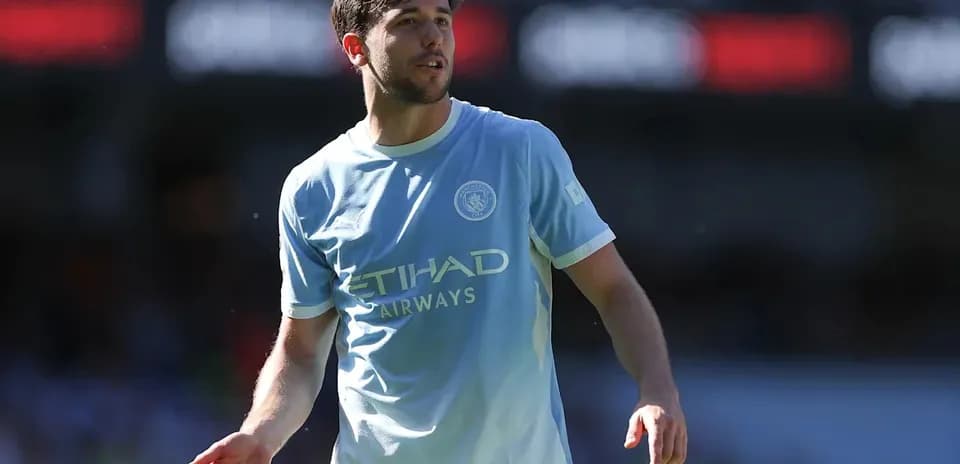 Player in light blue kit walking on the pitch