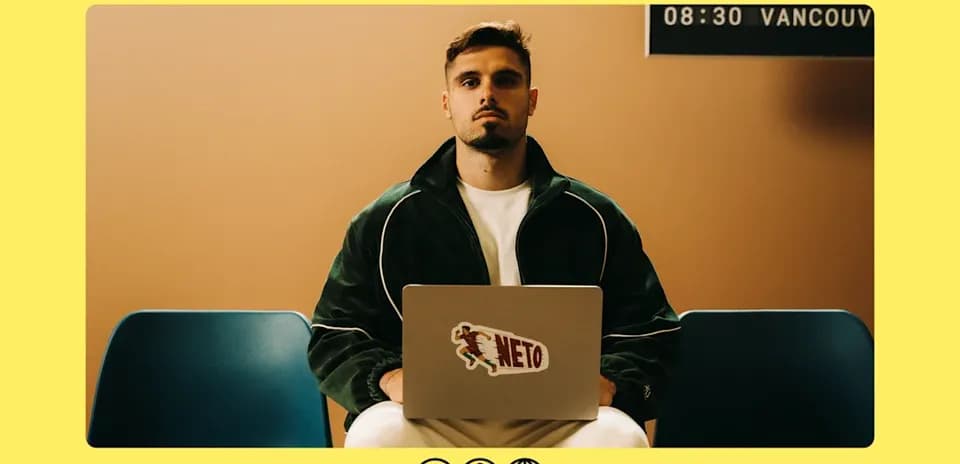 Man sitting with laptop, wearing green jacket