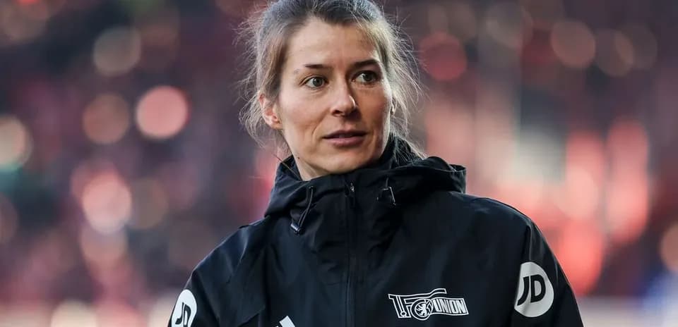 Female coach wearing a black jacket at stadium