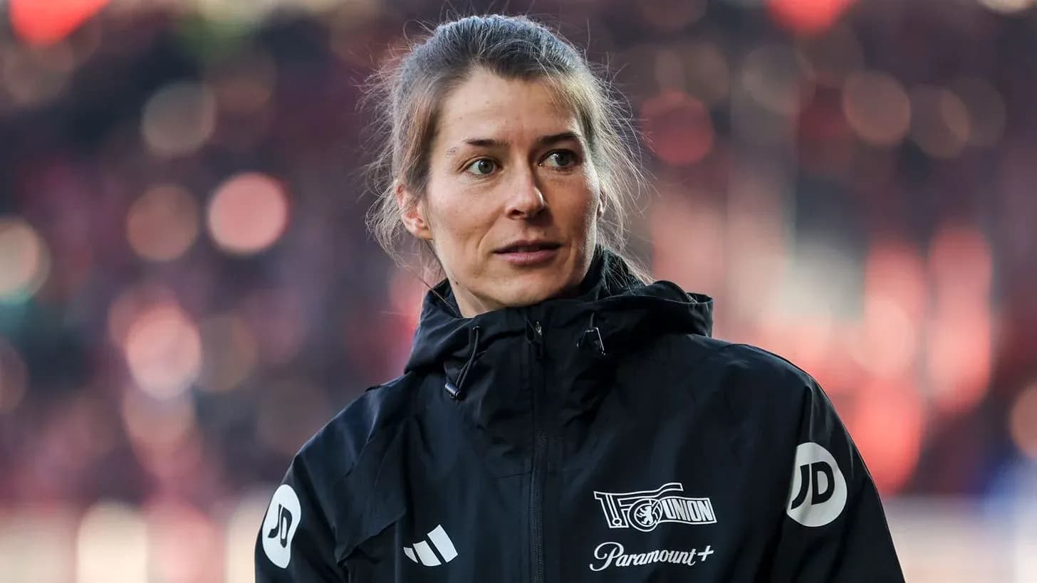 Female coach wearing a black jacket at stadium