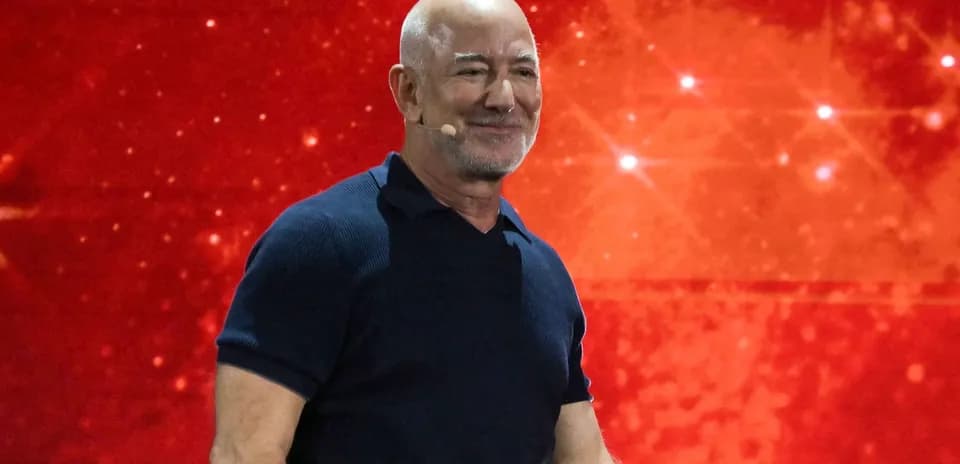 Person speaking on stage with red background