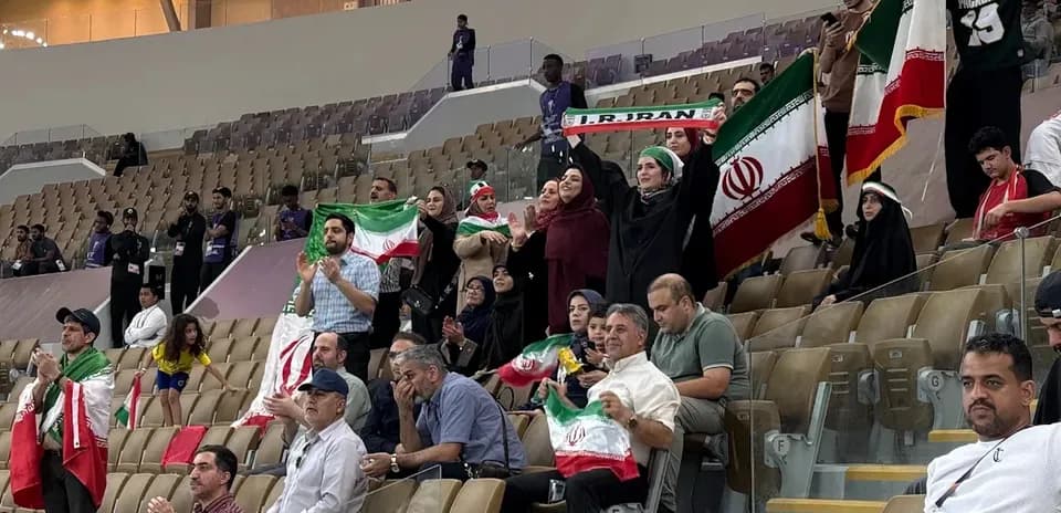 Iranian fans cheering with flags in stadium