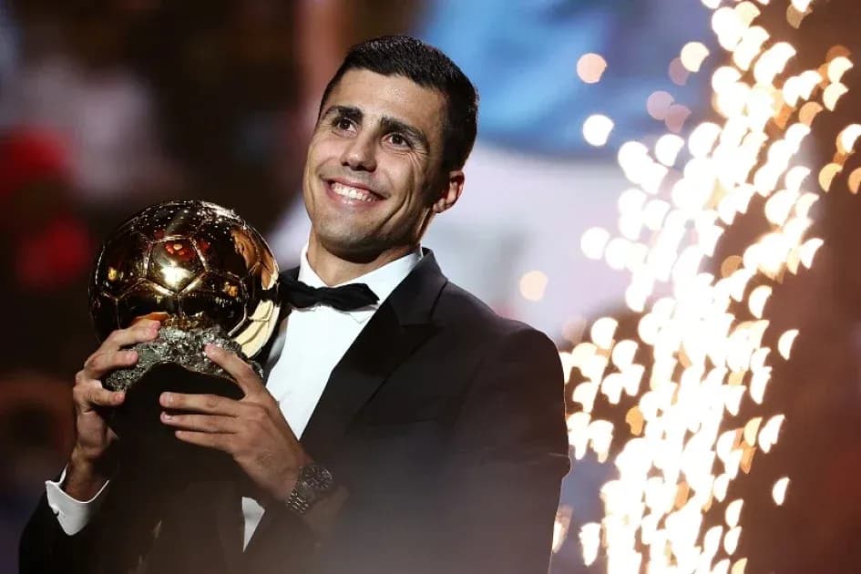 Player holding Ballon d'Or trophy on stage
