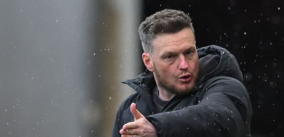 Manager gesturing during match in rainy conditions