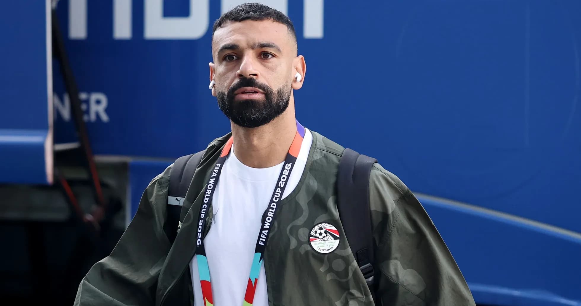 Player arriving at venue wearing headphones and jacket