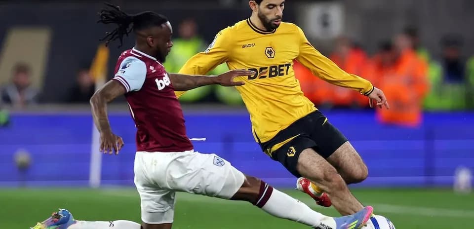 West Ham player tackling Wolves player during match