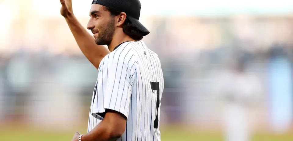 Man waving while wearing a pinstripe jersey