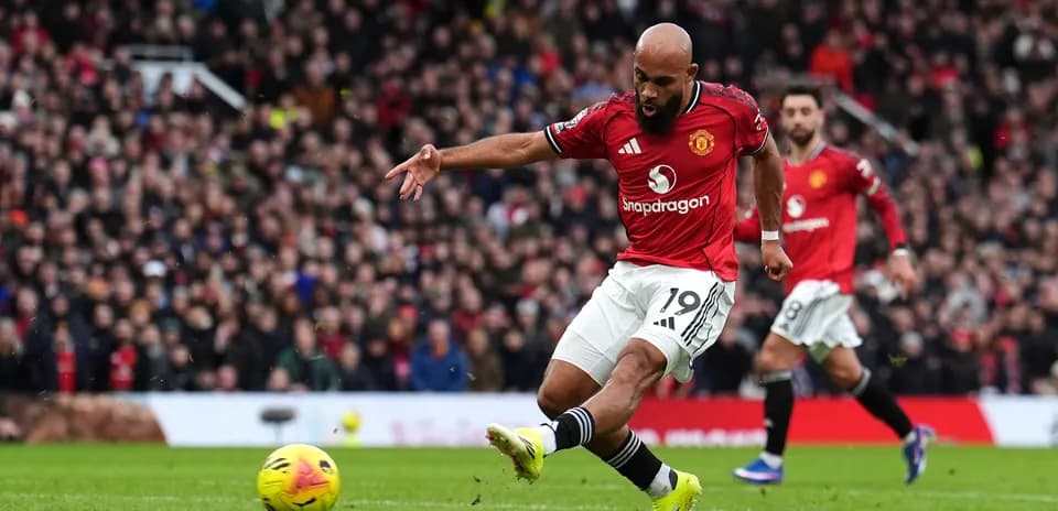 Player kicking ball during Manchester derby