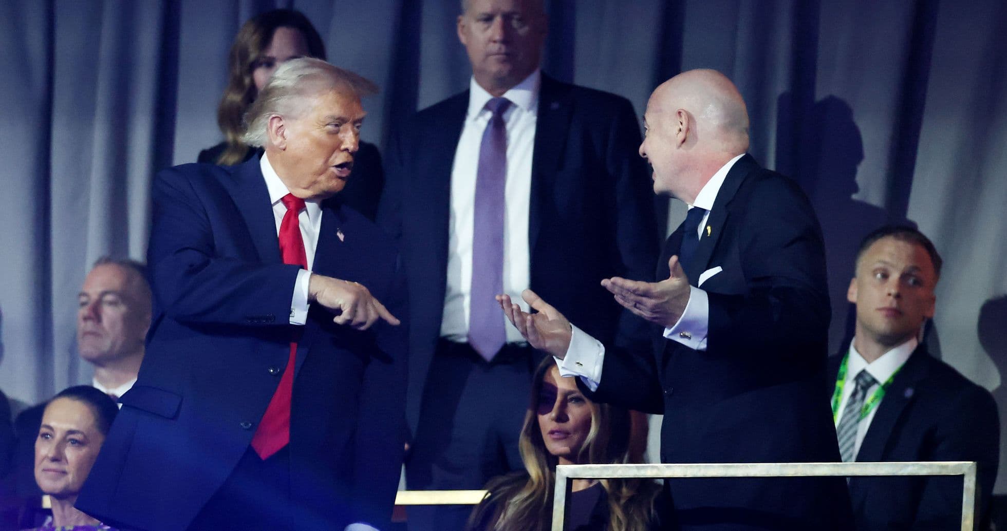 Two men conversing at an event with spectators