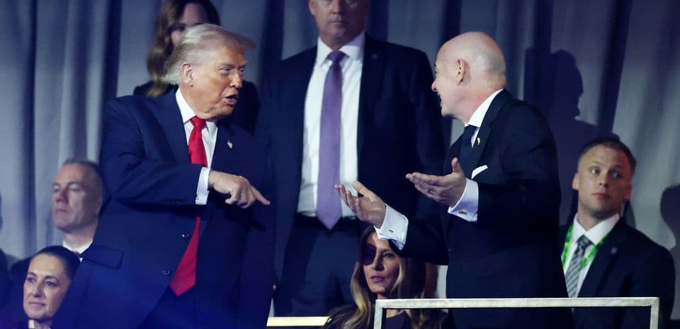 Two men conversing at an event with spectators