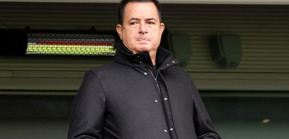 Person standing in a stadium wearing a black coat