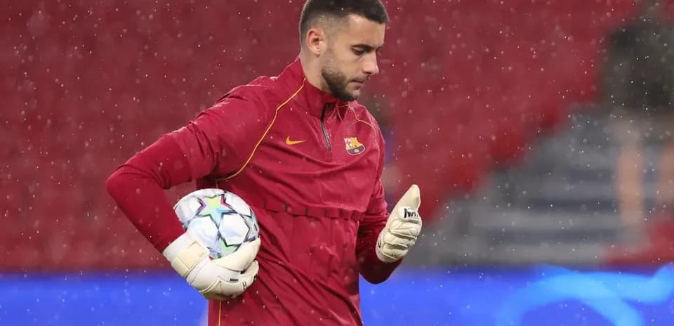 Goalkeeper in training with ball during rain