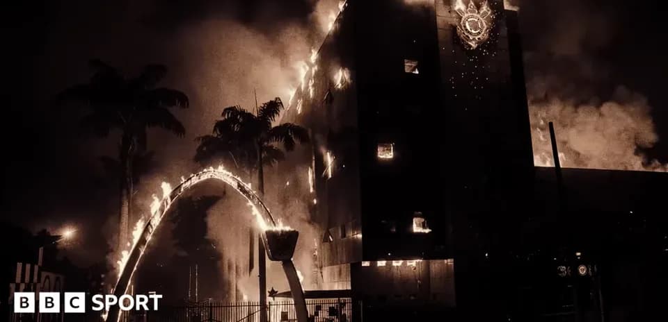 Building engulfed in flames with palm trees nearby