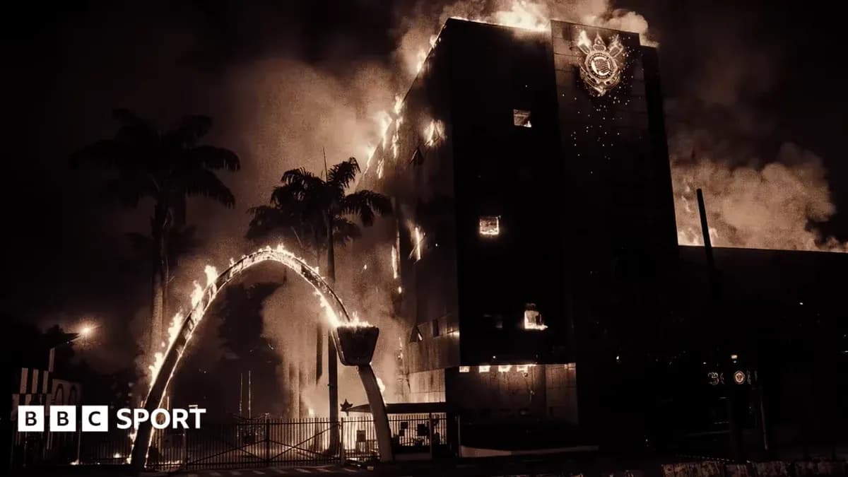 Building engulfed in flames with palm trees nearby