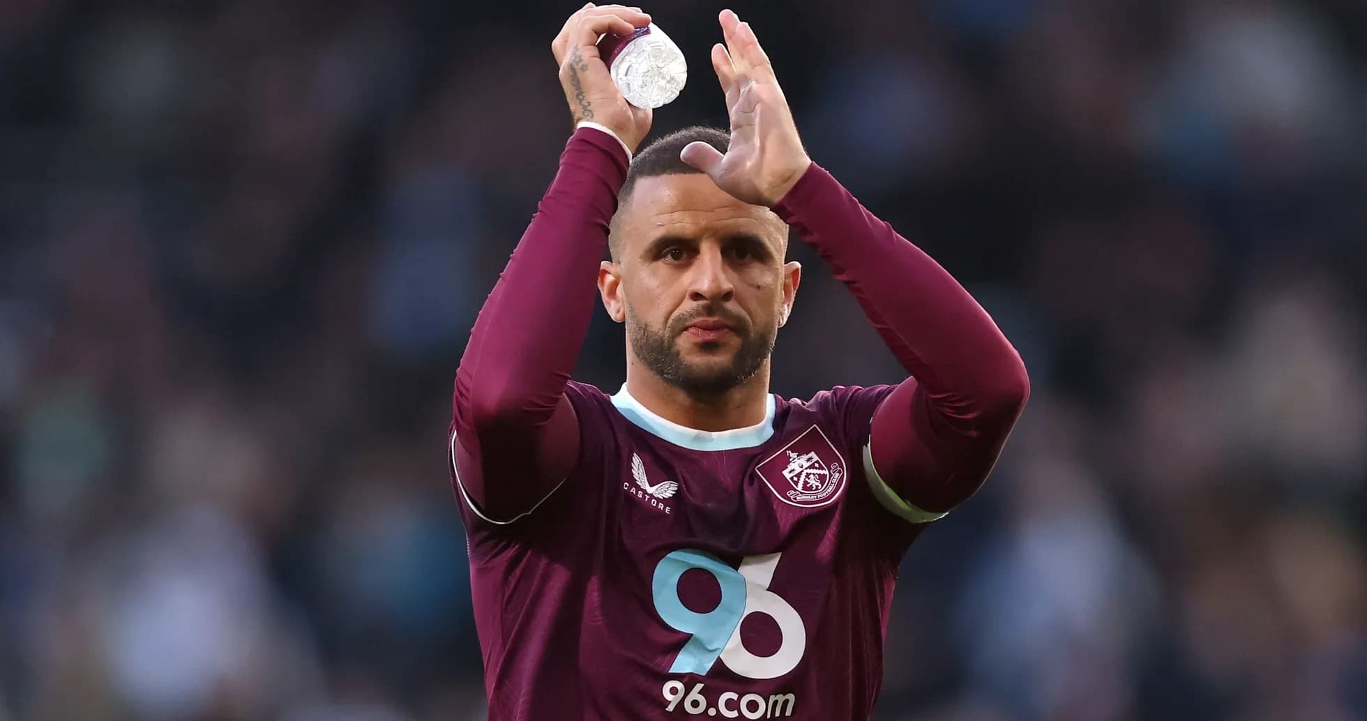 Player applauding fans while holding a water bottle