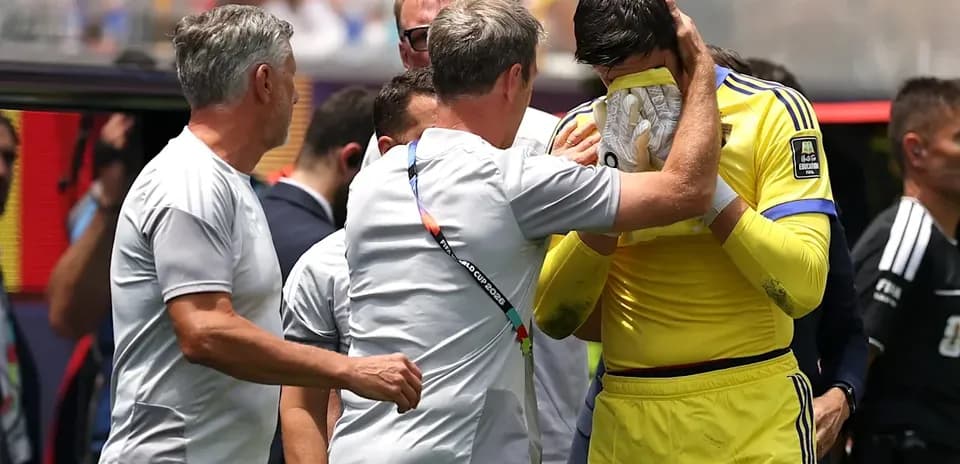 Coach comforting goalkeeper on the sidelines