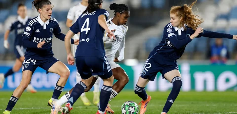 Real Madrid player dribbling against Paris FC defenders