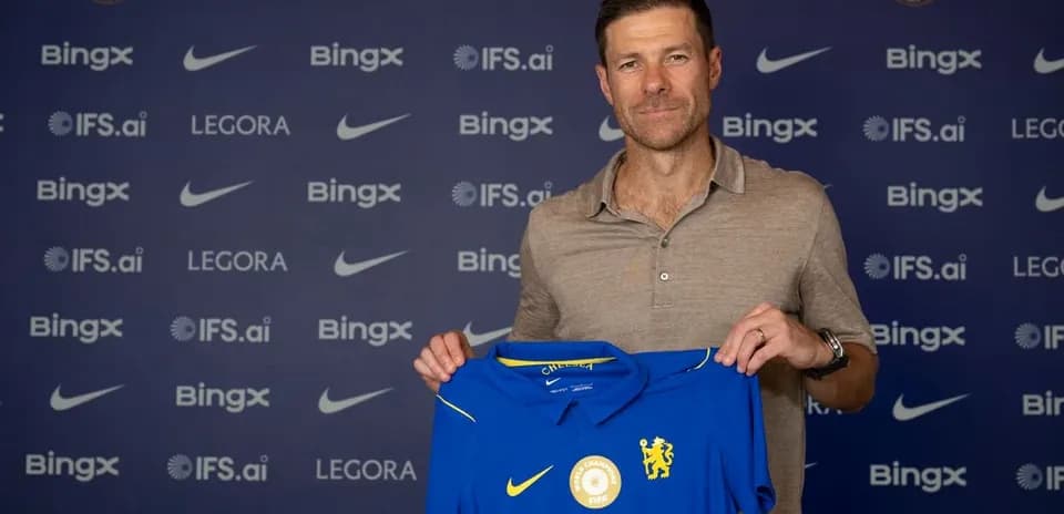 New manager holding Chelsea jersey at press event