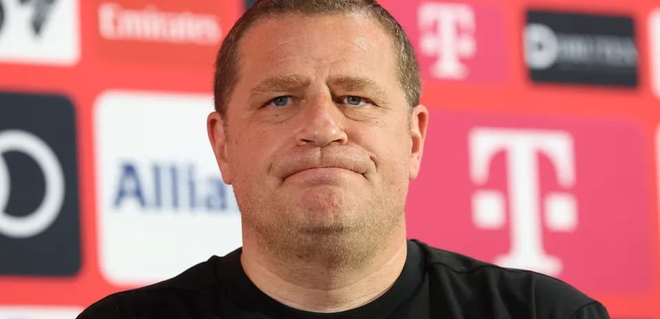 Man at press conference with team logos behind