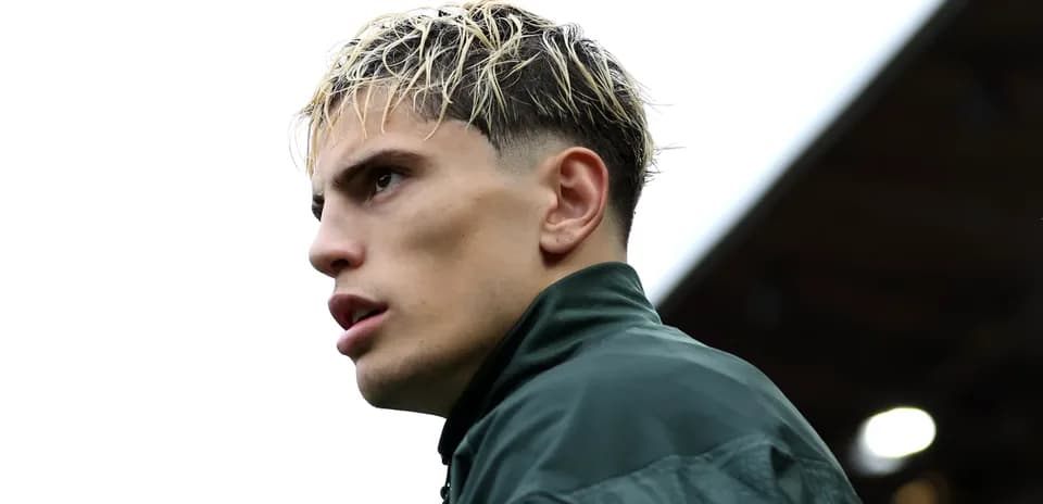 Player in green training jacket looking away