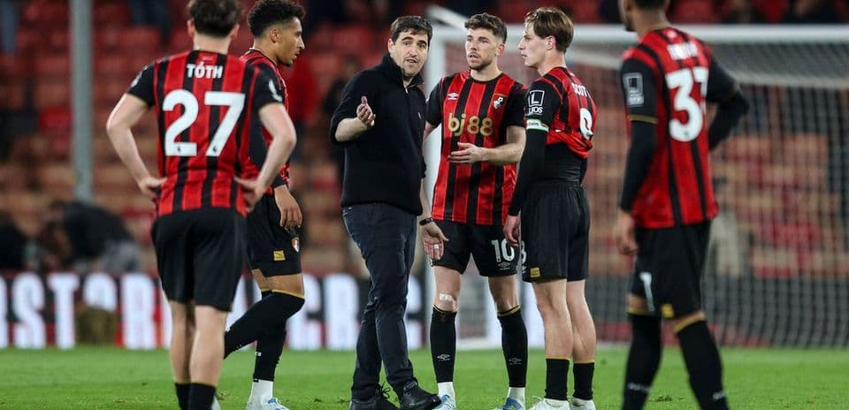 Coach discussing strategy with Bournemouth players during match