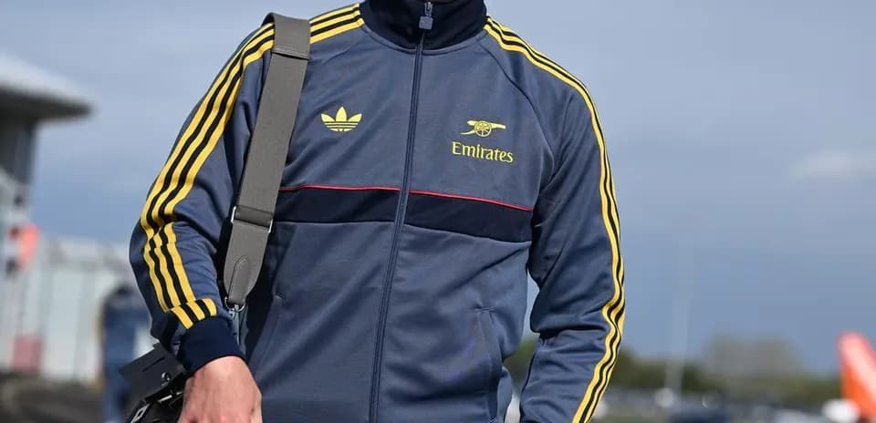 Athlete wearing tracksuit and cap walking outdoors