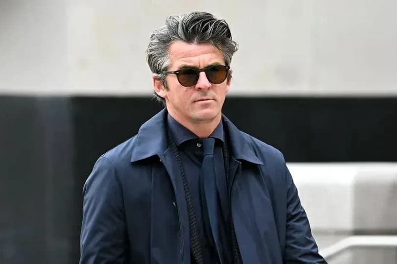 Man wearing sunglasses and a navy coat outdoors