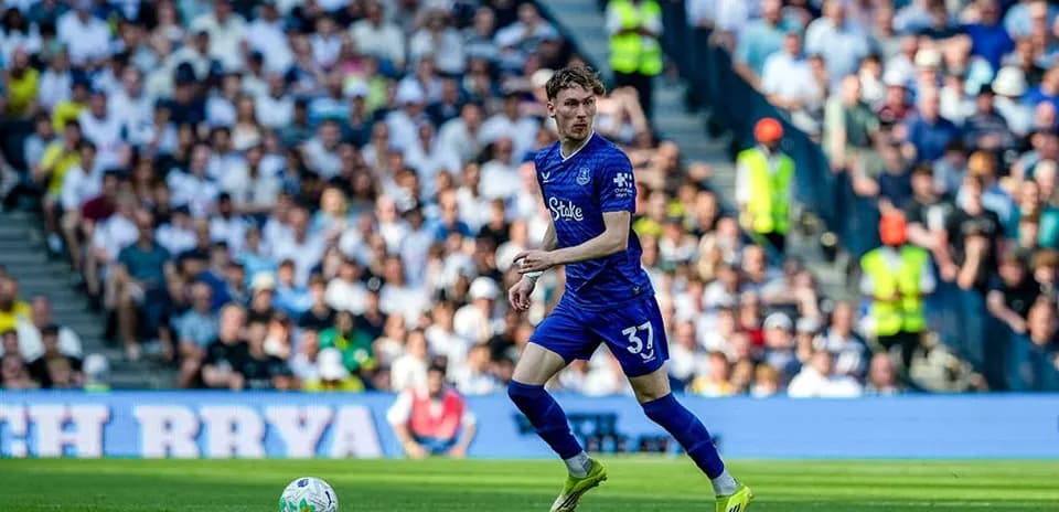 Player in blue jersey running with ball on field