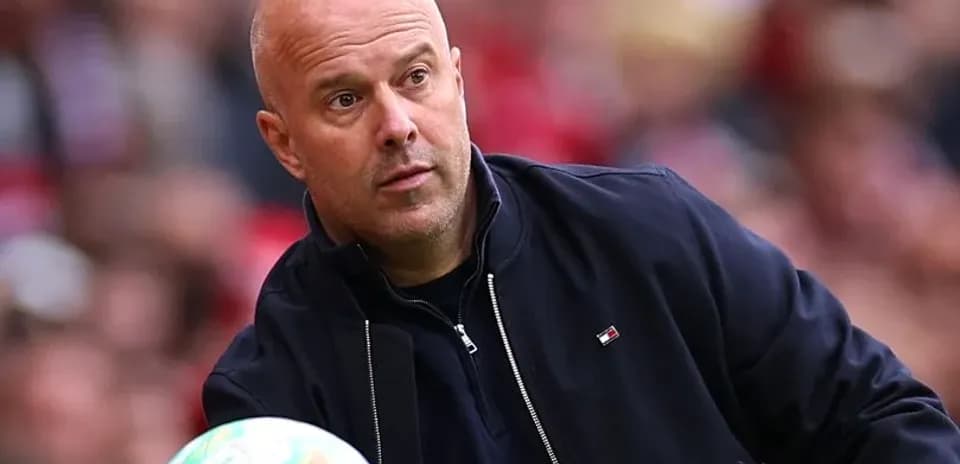 Coach holding a football on the sideline