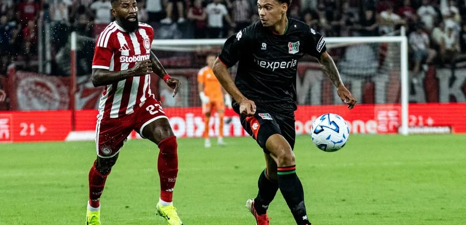 NEC Nijmegen player dribbling past Olympiakos defender