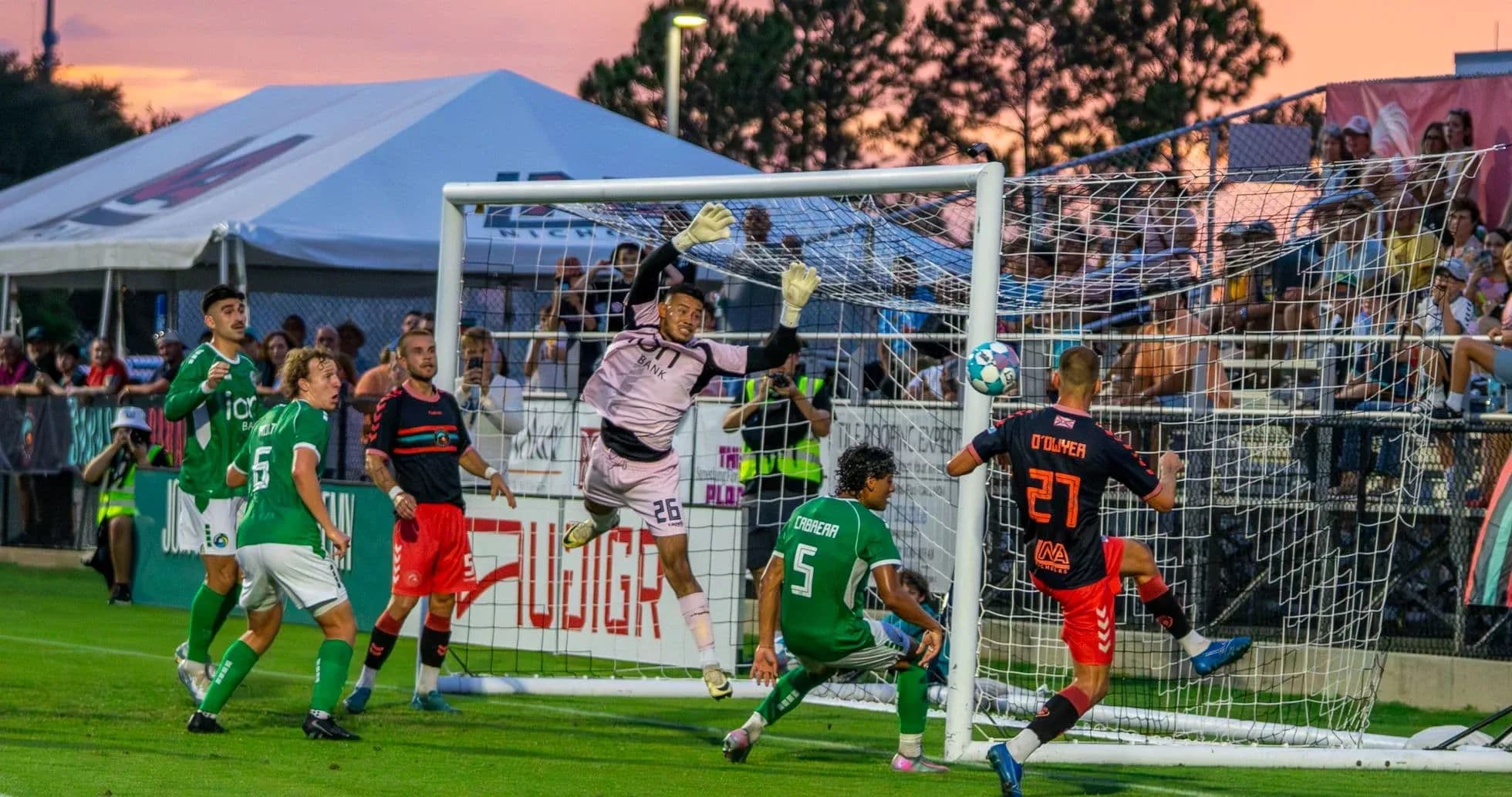 Goalkeeper attempting to save shot during match