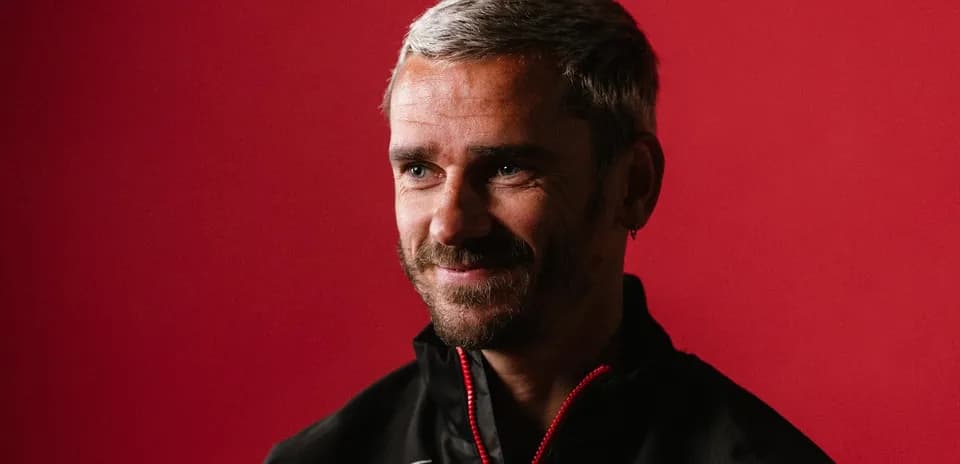 Man with gray hair smiling against red background