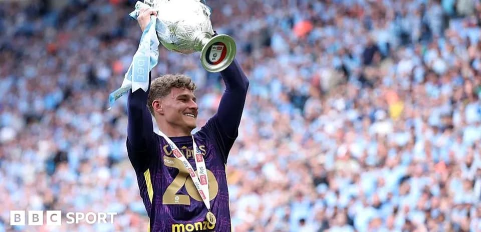 Goalkeeper celebrating with trophy at stadium