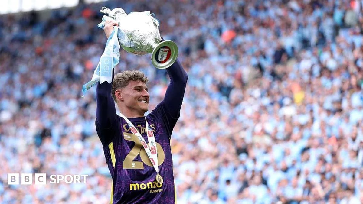 Goalkeeper celebrating with trophy at stadium