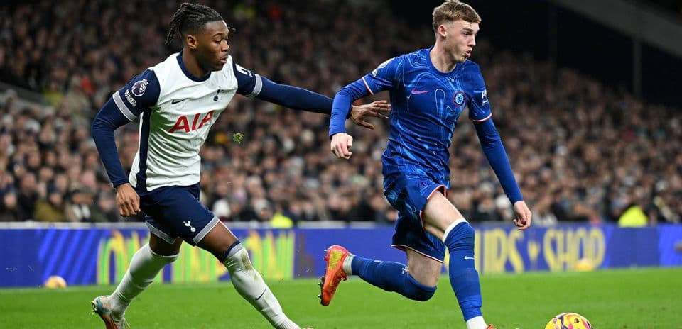 Chelsea player evading Tottenham defender during match