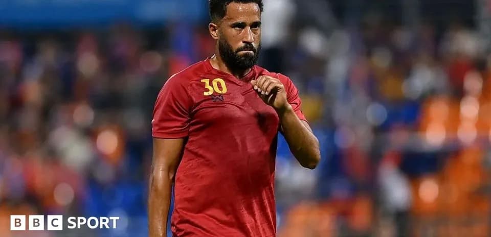 Player in red jersey walking on the field