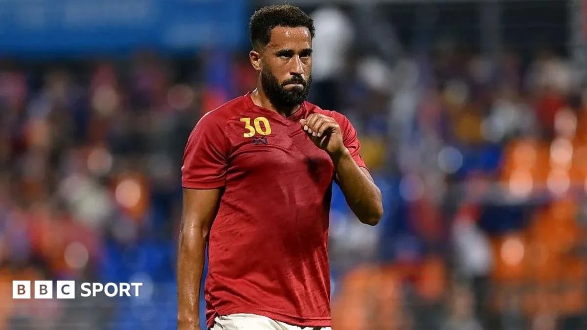 Player in red jersey walking on the field