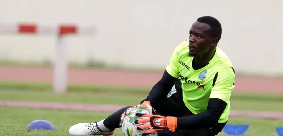 Goalkeeper training on the pitch, catching a ball