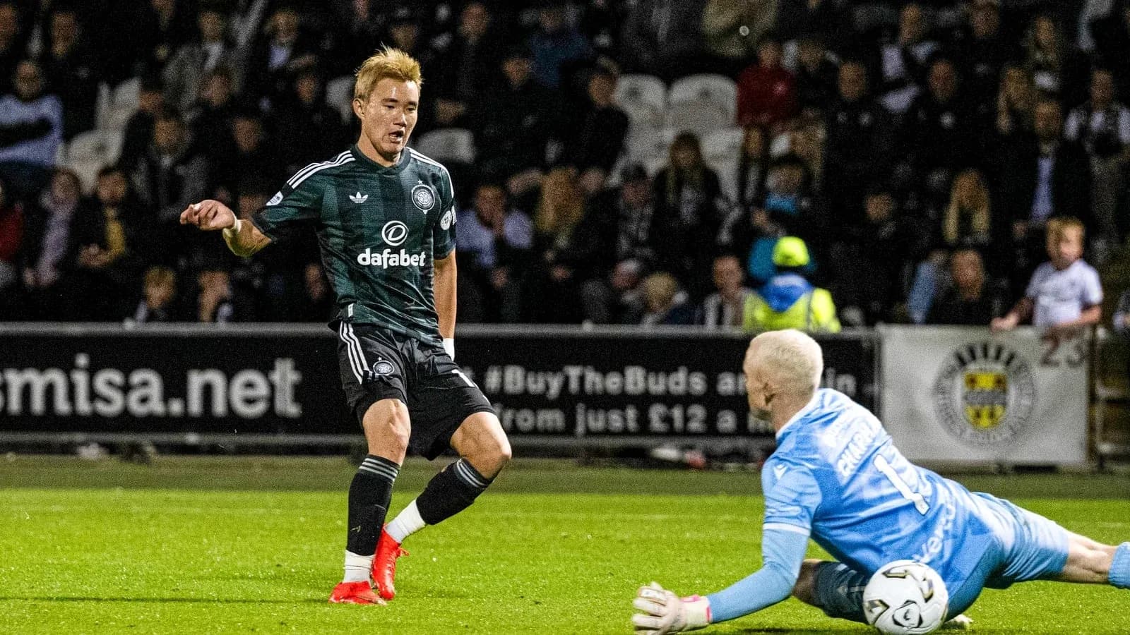 Player dribbling past goalkeeper during match action