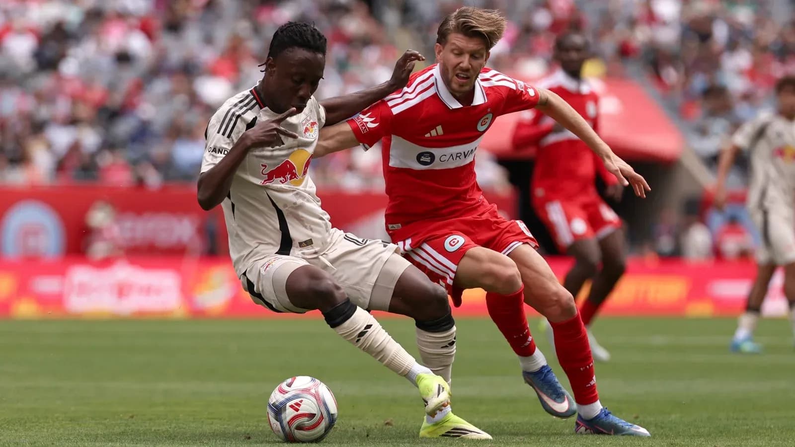New York Red Bulls player challenging Chicago Fire opponent
