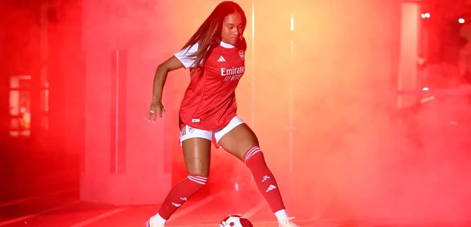 Player in Arsenal kit posing with soccer ball
