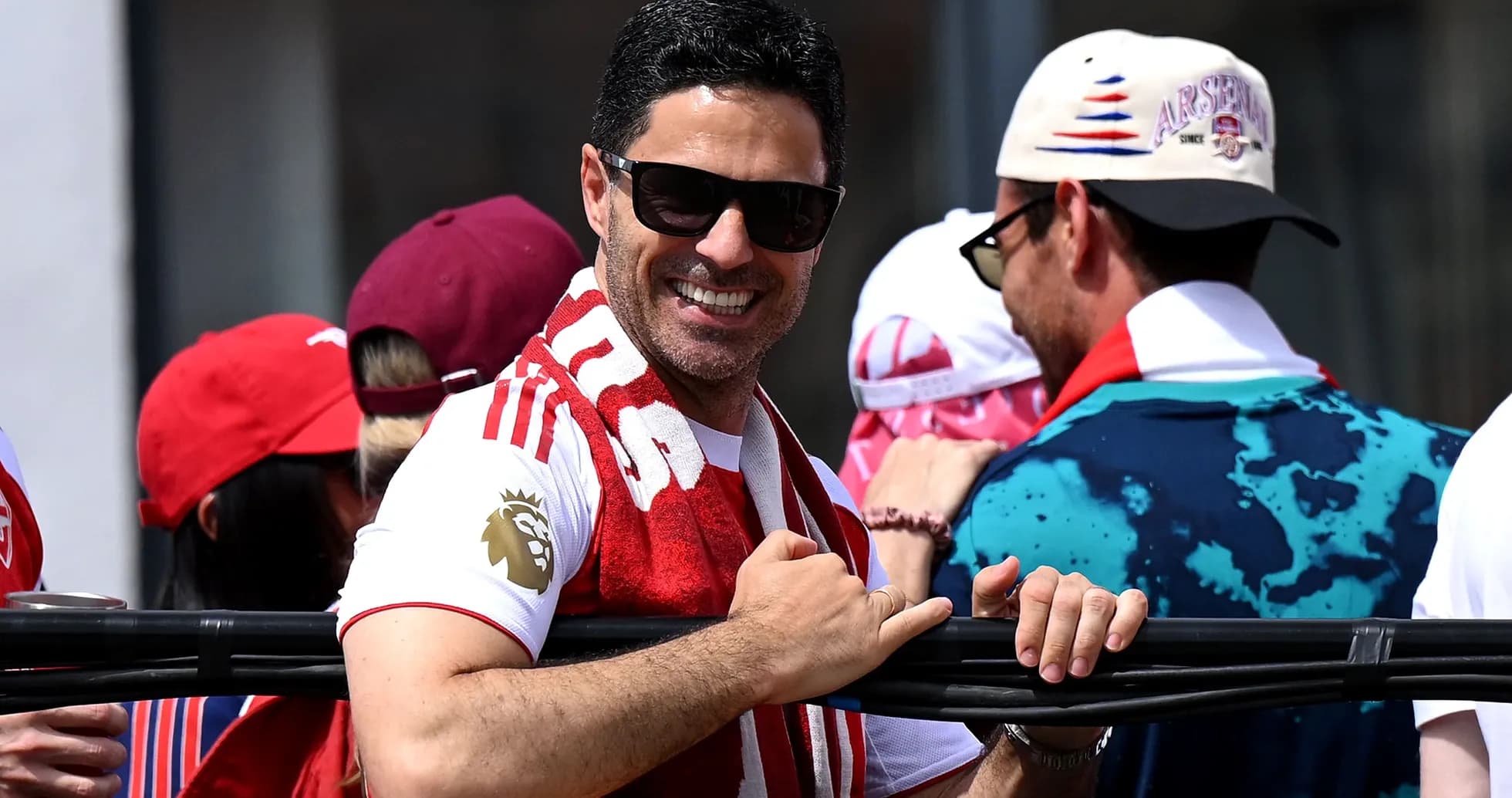 Man smiling while wearing an Arsenal scarf