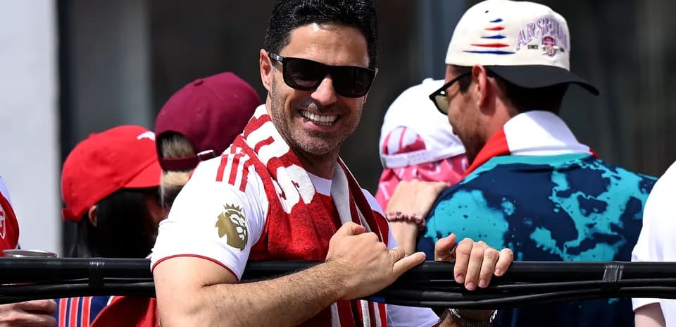 Man smiling while wearing an Arsenal scarf