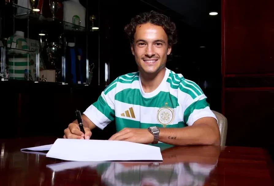 Player signing contract in Celtic jersey at table