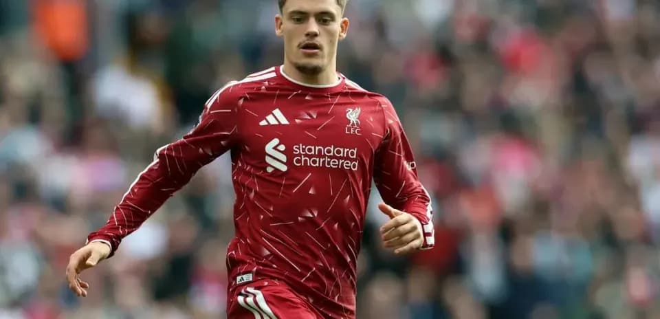 Player running on pitch in Liverpool kit