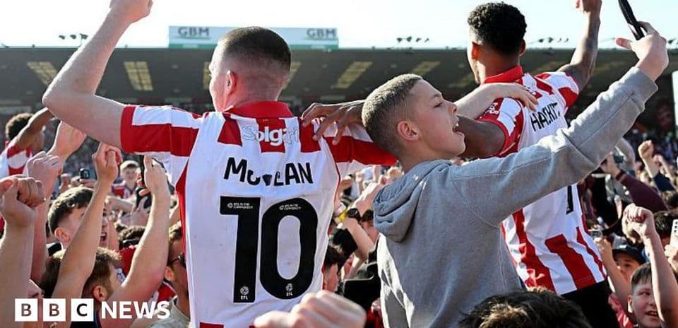 Fans celebrating with players on the pitch