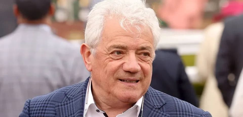 Man with white hair wearing a checkered jacket